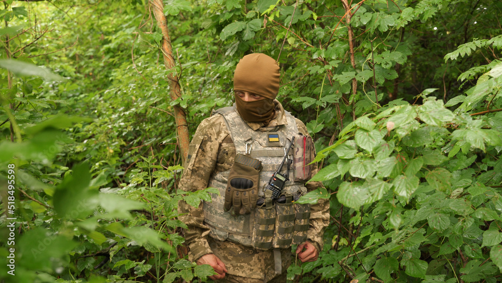 Ukrainian soldier hides from enemy attack in the forest. shelling. mortar shelling, aircraft attack on infantry positions. a soldier watching the enemy army in a forest shelter