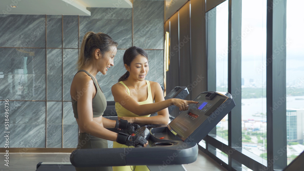 Portrait of fit healthy Asian woman with trainer coach, people, running or jogging on treadmill, and training in gym or fitness center in sport and recreation concept. Lifestyle activity.