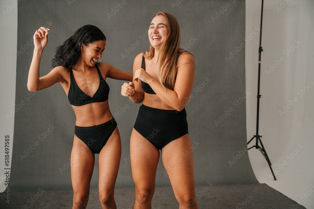 Two diverse women in their black underwear having fun in the studio Stock  Photo