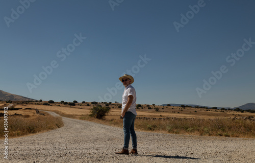 Adult man in cowboy hat on dirt road against sky. Castilla y Leon, Spain