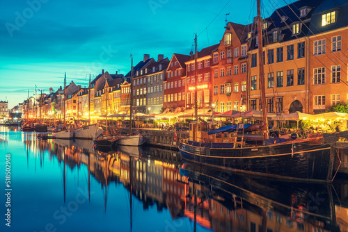 Beautiful view with colorful facade of traditional houses and old wooden ships along the Nyhavn Canal or New Harbour, canal and entertainment district, night view