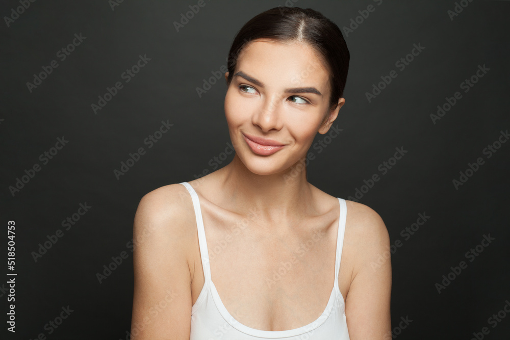 Portrait of cute woman smiling and looking aside on black background Portrait of cute woman smiling and looking aside on black background
