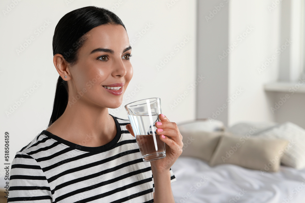 Young woman with glass of water indoors, space for text. Refreshing drink Young woman with glass of water indoors, space for text. Refreshing drink