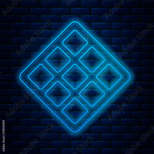 Glowing neon line Waffle icon isolated on brick wall background. Vector