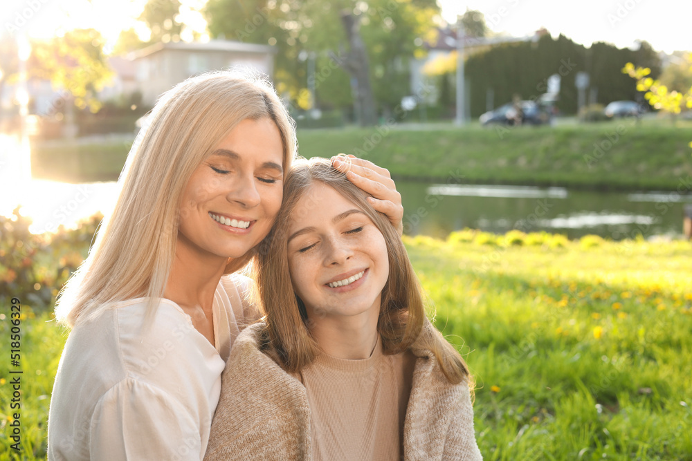 Happy mother with her daughter spending time together in park on sunny day Happy mother with her daughter spending time together in park on sunny day