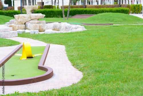 Green lawn with fresh grass, mini golf course and fountain outdoors
