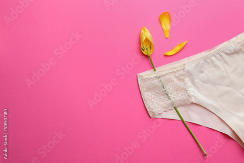 Quadro su tela Yellow tulip and panties on pink background, top view with space for text