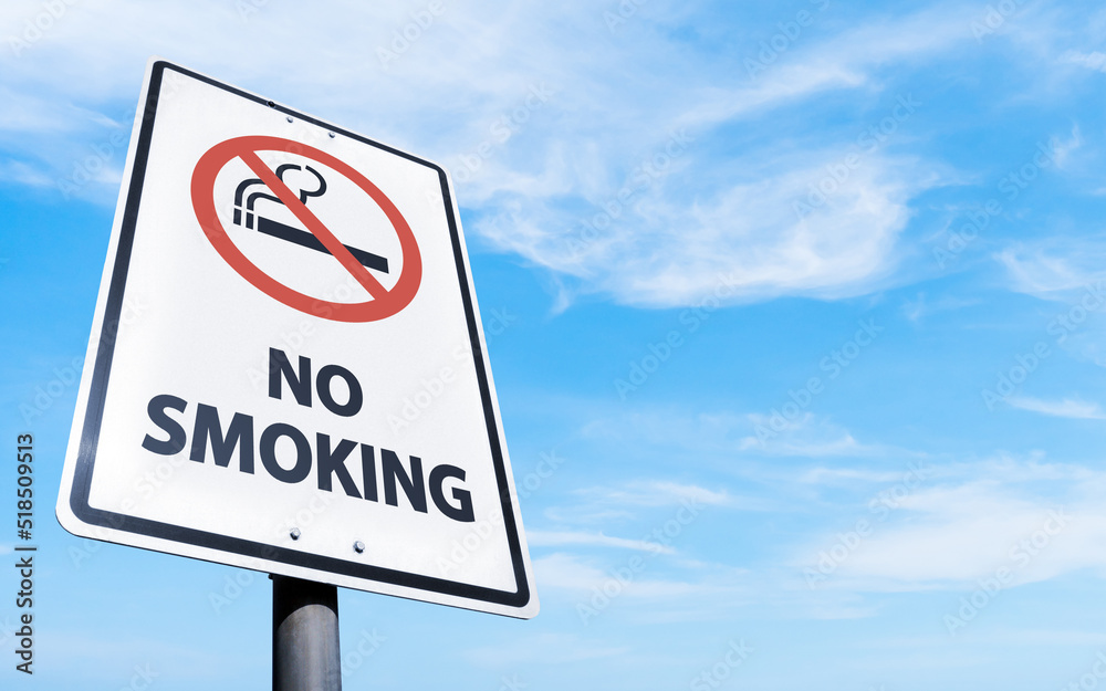 Rectangular no smoking sign, blue sky and clouds background. Road sign of prohibition of smoking in the open air. Rectangular no smoking sign, blue sky and clouds background. Road sign of prohibition of smoking in the open air.