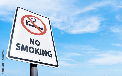 Rectangular no smoking sign, blue sky and clouds background. Road sign of prohibition of smoking in the open air.