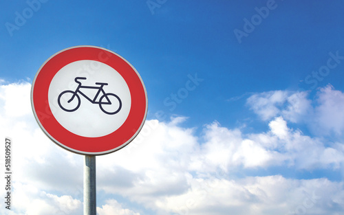 Round bicycle sign transit prohibited for bicycles on a blue sky background. Bicyle road sign, prohibition red sign.