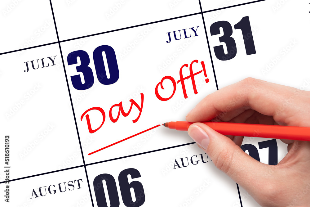 30th day of July. Hand writing text DAY OFF and drawing a line on calendar date 30 July. Vacation planning concept. Summer month, day of the year concept. 30th day of July. Hand writing text DAY OFF and drawing a line on calendar date 30 July. Vacation planning concept. Summer month, day of the year concept.