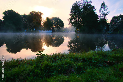 Fototapeta Naklejka Na Ścianę i Meble -  A sunrise at dawn, with fog on the river and warm light atmosphere. Landscape shot