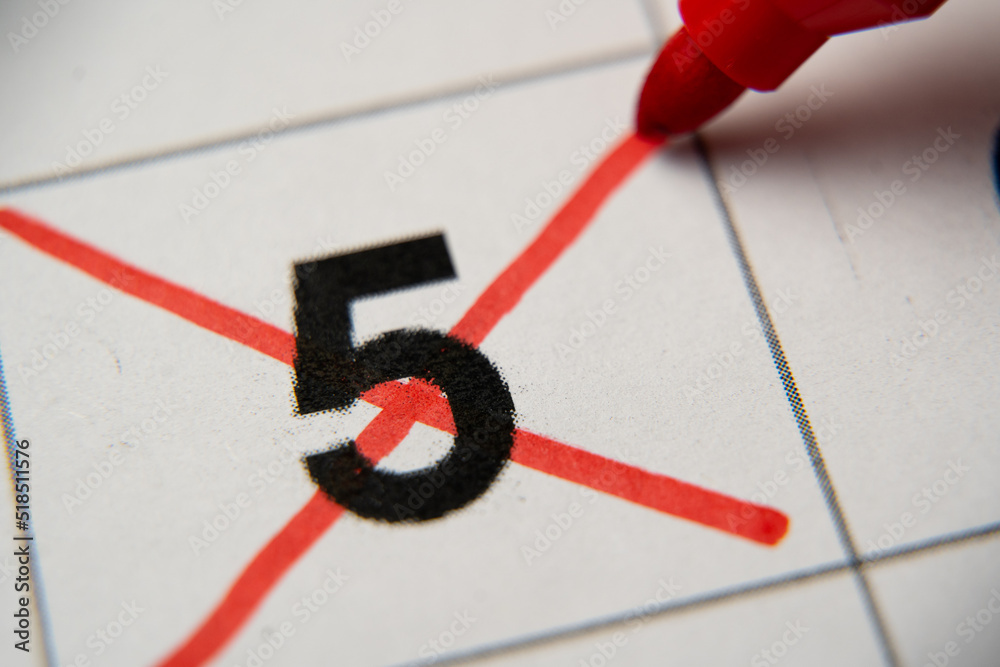 The 5st number in the calendar is crossed out with a red cross in a macro on a white sheet. Calendar for plans, notes, meetings. Business calendar. Marker for notes in the calendar The 5st number in the calendar is crossed out with a red cross in a macro on a white sheet. Calendar for plans, notes, meetings. Business calendar. Marker for notes in the calendar