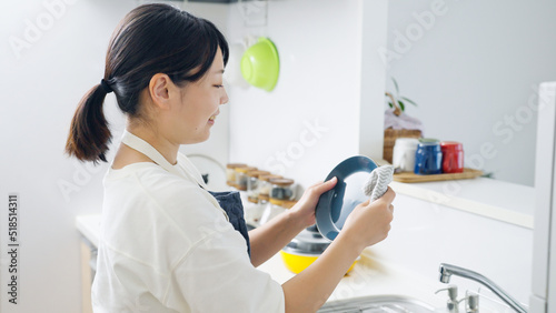 キッチンで皿を拭く女性（家事・主婦）