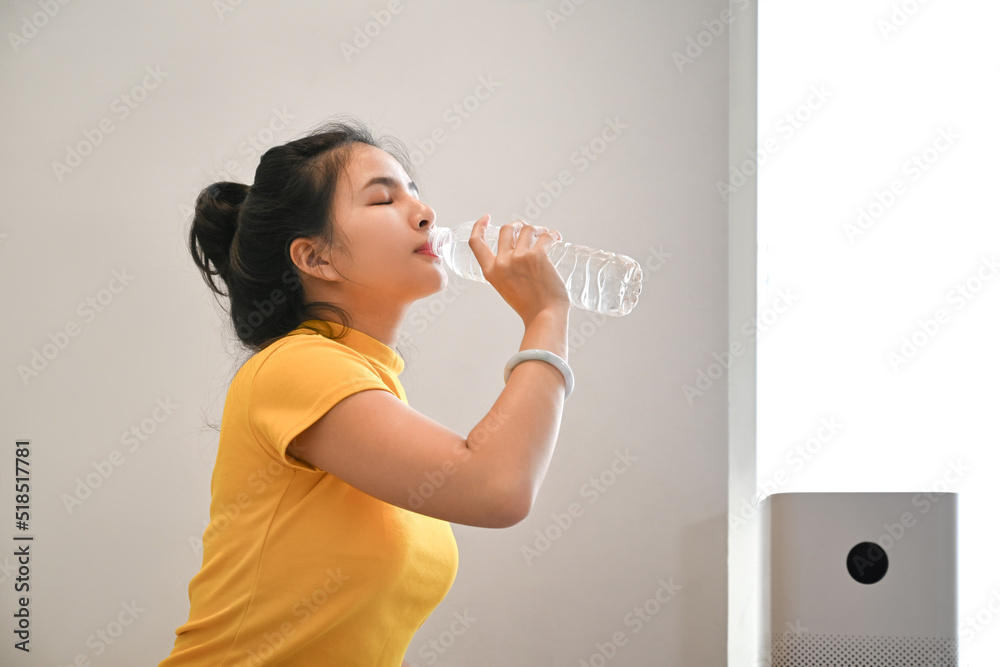 Healthy young woman in sports clothes drinking water and resting after morning workout Healthy young woman in sports clothes drinking water and resting after morning workout