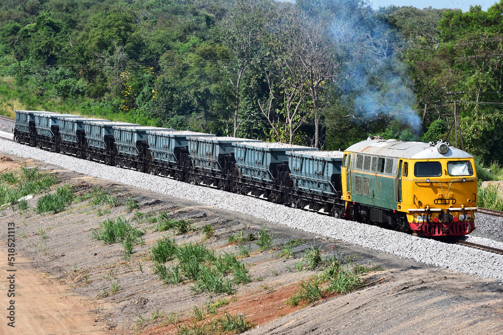 Naklejka premium Hopper-freight train by diesel locomotive on the railway in Thailand