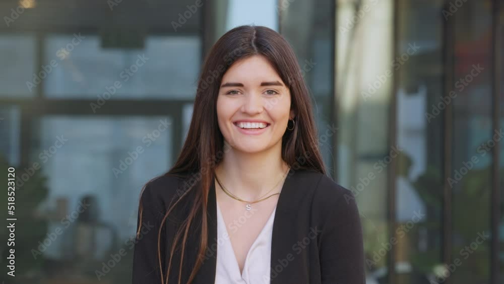 Portrait of a happy laughing female looking surprised at the camera. Cheerful caucasian young lady laughing, excited to see a friend. A beautiful smiling woman standing outside her work office Portrait of a happy laughing female looking surprised at the camera. Cheerful caucasian young lady laughing, excited to see a friend. A beautiful smiling woman standing outside her work office