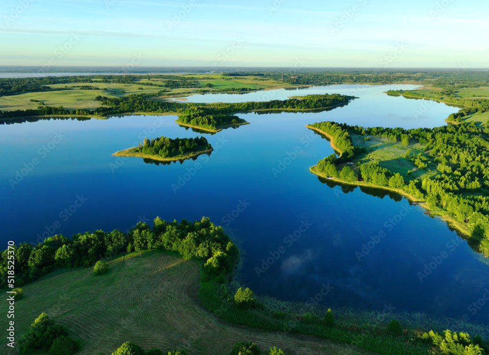 Naklejka premium Lake in morning mist sunrise. Rural landscape. Lake mist haze. Countryside at dawn in fog, drone view. Lake in Foggy dawn. Pond in dusk at rural fog landscape. Drink water safe. Global drought crisis.