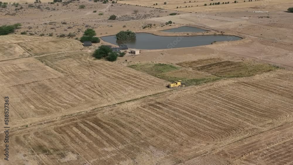 Aerial High Angle View Of Yellow Combine Harvester Working In Rural Punjab Field. Parallax Shot Aerial High Angle View Of Yellow Combine Harvester Working In Rural Punjab Field. Parallax Shot
