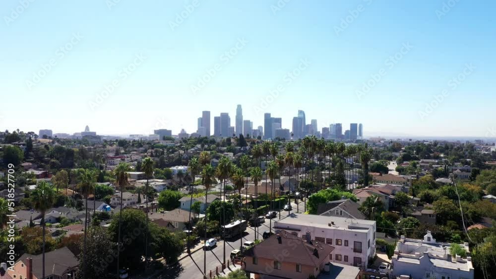 Beautiful drone shot flys up to show Los Angeles, California's Echo Park neighborhood, covered in palm trees with city skyline in background Beautiful drone shot flys up to show Los Angeles, California's Echo Park neighborhood, covered in palm trees with city skyline in background