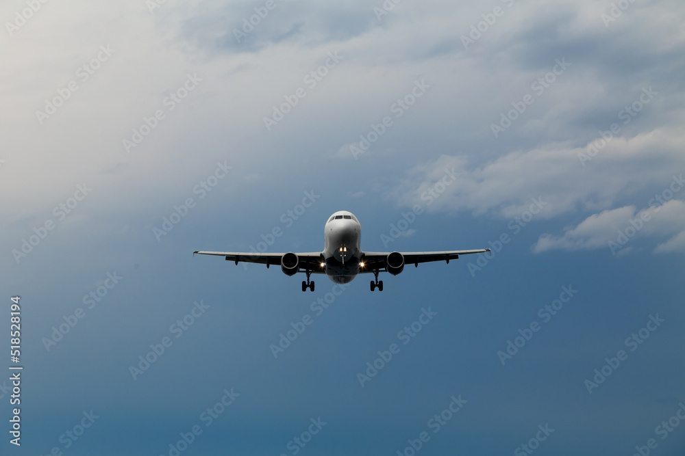 Airplane in the dark stormy sky. Landing plane.