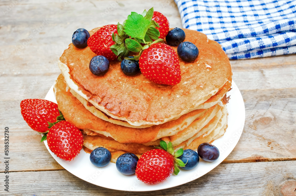 Pancakes with strawberries and blueberries on the table. Pancakes with strawberries and blueberries on the table.