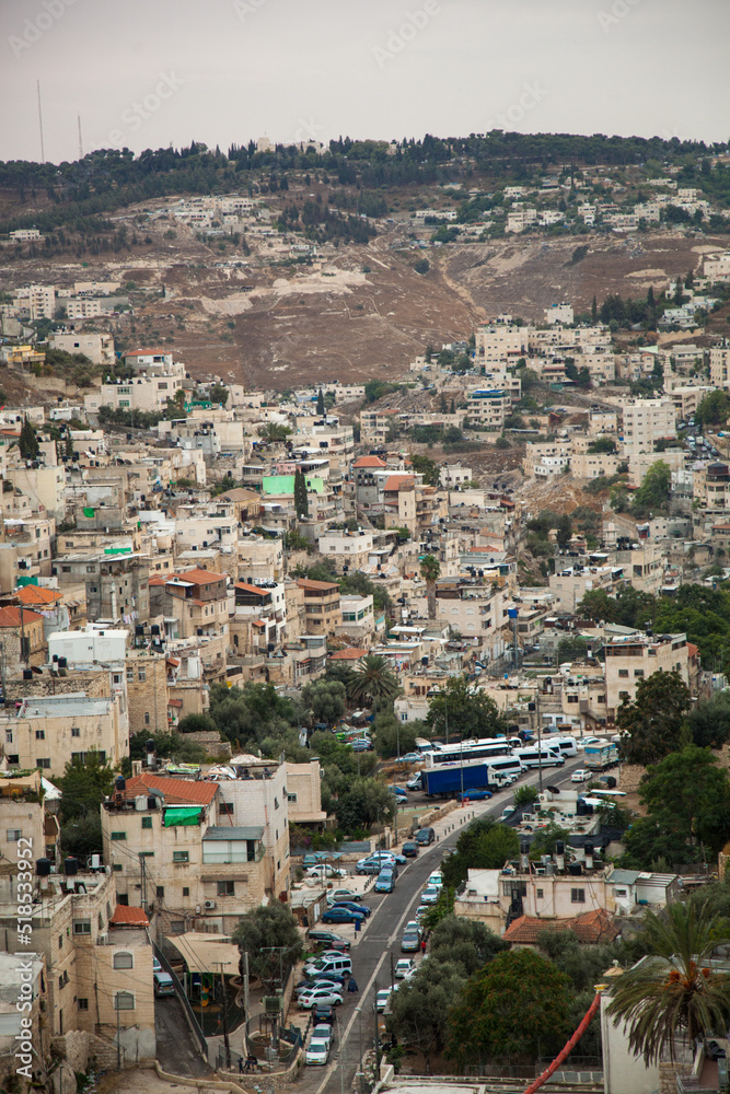 Vertical photograph of an urban slum in Israel. Dense urban development and garbage. Street passing through the houses with a view from above. Jerusalem buildings