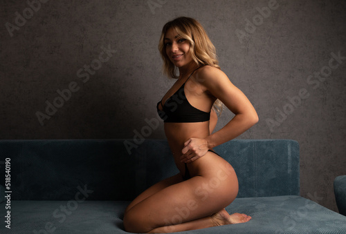Sensual blond woman in lingerie lying on a sofa