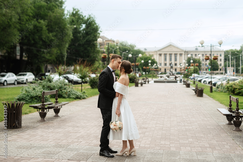 Fototapeta premium young couple bride and groom in a white short dress