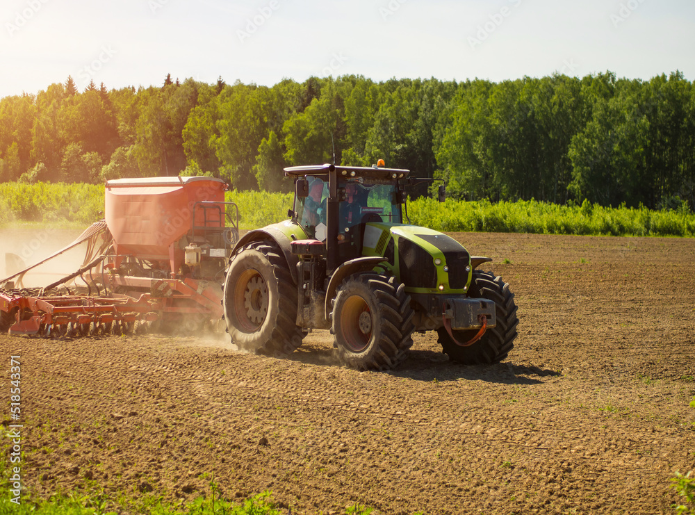 Collective farmers sow, sow crops in the field. big tractor working in the field, harvesting, doing business, farming. soil preparation for planting Collective farmers sow, sow crops in the field. big tractor working in the field, harvesting, doing business, farming. soil preparation for planting
