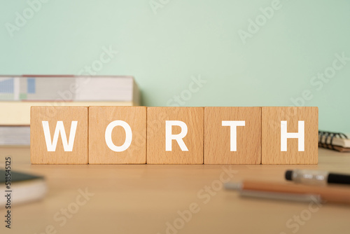 価値のイメージ｜「WORTH」と書かれたブロックが置かれたデスク 