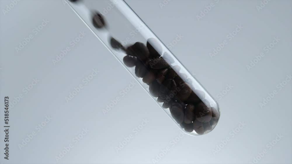 Video clip coffee bean falling into test tube for research on coffee , coffee extract for health and skin care , science content Video clip coffee bean falling into test tube for research on coffee , coffee extract for health and skin care , science content