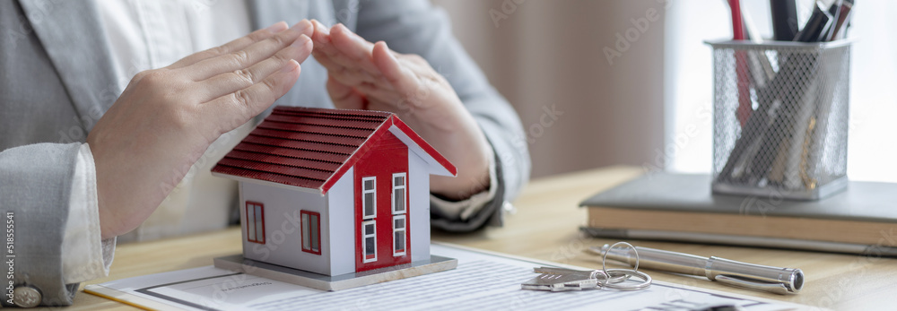 Φωτογραφία Selling a house with insurance, Salesperson or head of sales uses their hands to protect their model home as a symbol with buy a home get free insurance, Real estate or after sales service