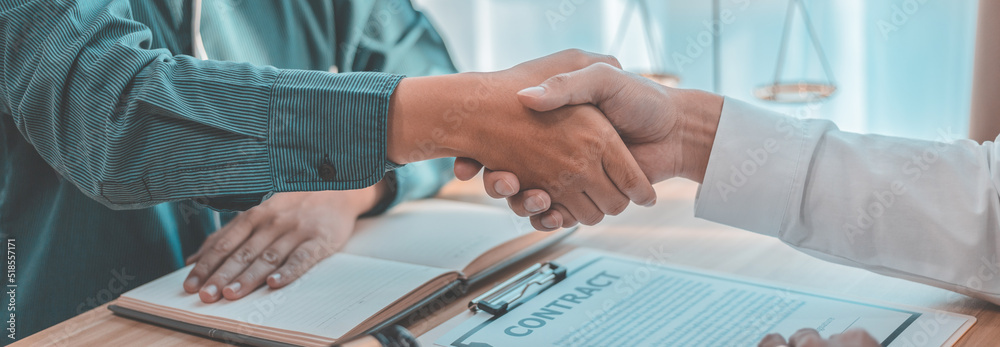 Businessman shaking hands with a lawyer or judge After signing the contract and the agreement is complete, Approval of an agreement between business and law, End of the legal case. Businessman shaking hands with a lawyer or judge After signing the contract and the agreement is complete, Approval of an agreement between business and law, End of the legal case.