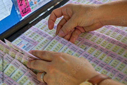 Gamblers are searching for Thai lottery numbers on the panel. Hope to win the big random prize.