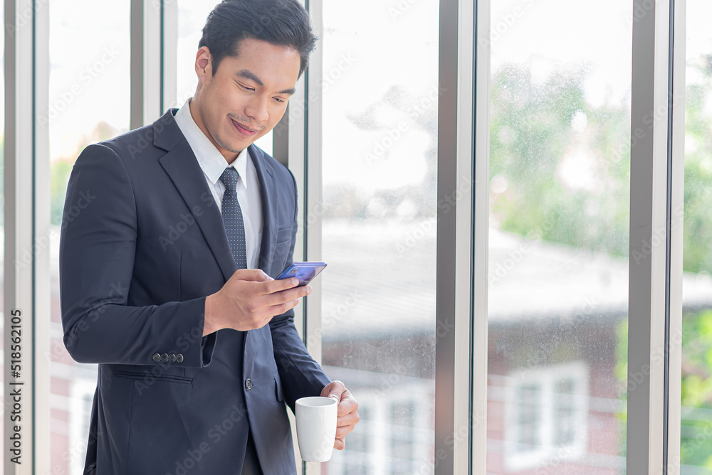 asian business man drink coffee and use mobile phone asian business man drink coffee and use mobile phone