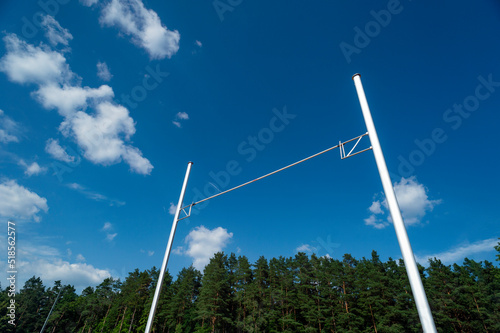 Pole vault against blue sky with sun. Horizontal sport theme poster, greeting cards, headers, website and app photo