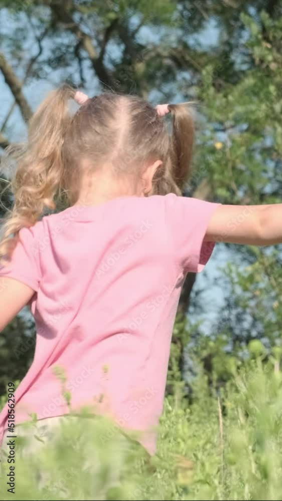 VERTICAL VIDEO: Little girl plays with butterfly net of tall grass in city park. Cute little girl is playing with aerial insect net in meadow on sun day. Slow motion VERTICAL VIDEO: Little girl plays with butterfly net of tall grass in city park. Cute little girl is playing with aerial insect net in meadow on sun day. Slow motion