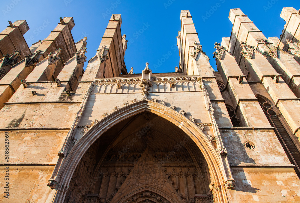 The facade of the cathedral on the island of Palma de Mallorca, viewed from below during the day.