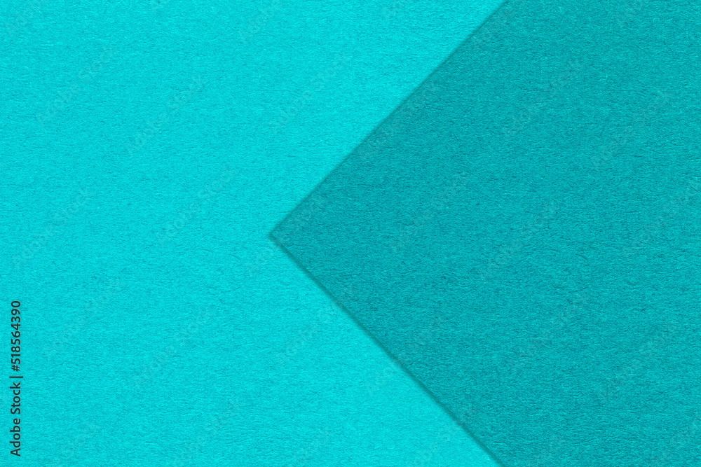 Texture of turquoise and cerulean paper background, half two colors with arrow. Structure of craft azure cardboard