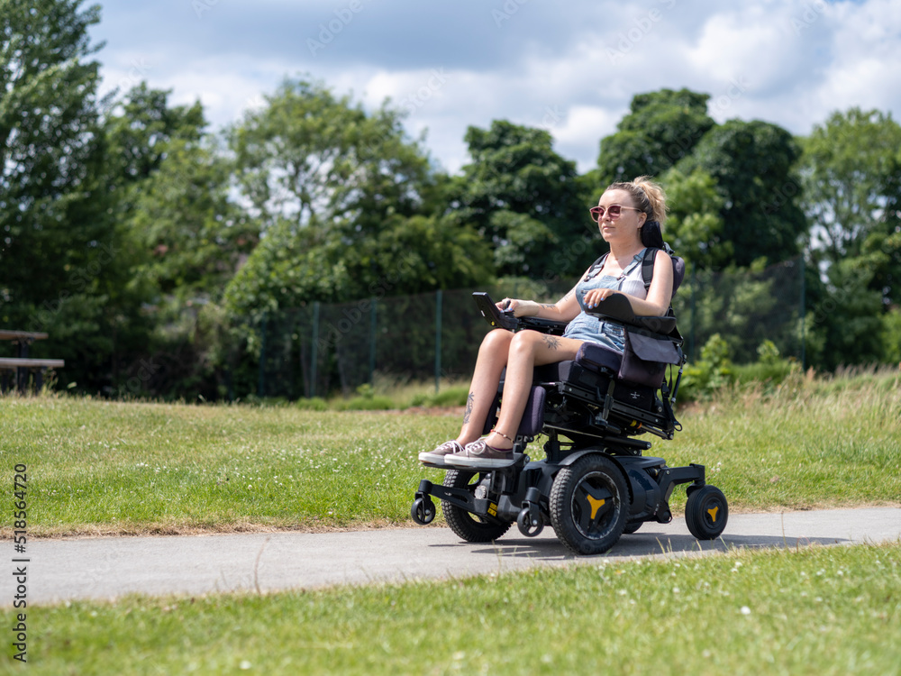 Woman in electric wheelchair going on walk Woman in electric wheelchair going on walk