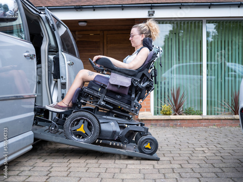Woman in electric wheelchair getting in van