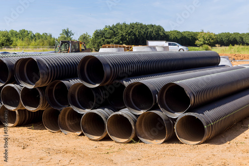 Wallpaper Mural In order to build a drain system on construction site, PVC new black plastic pipes are stacked in rows for new home Torontodigital.ca