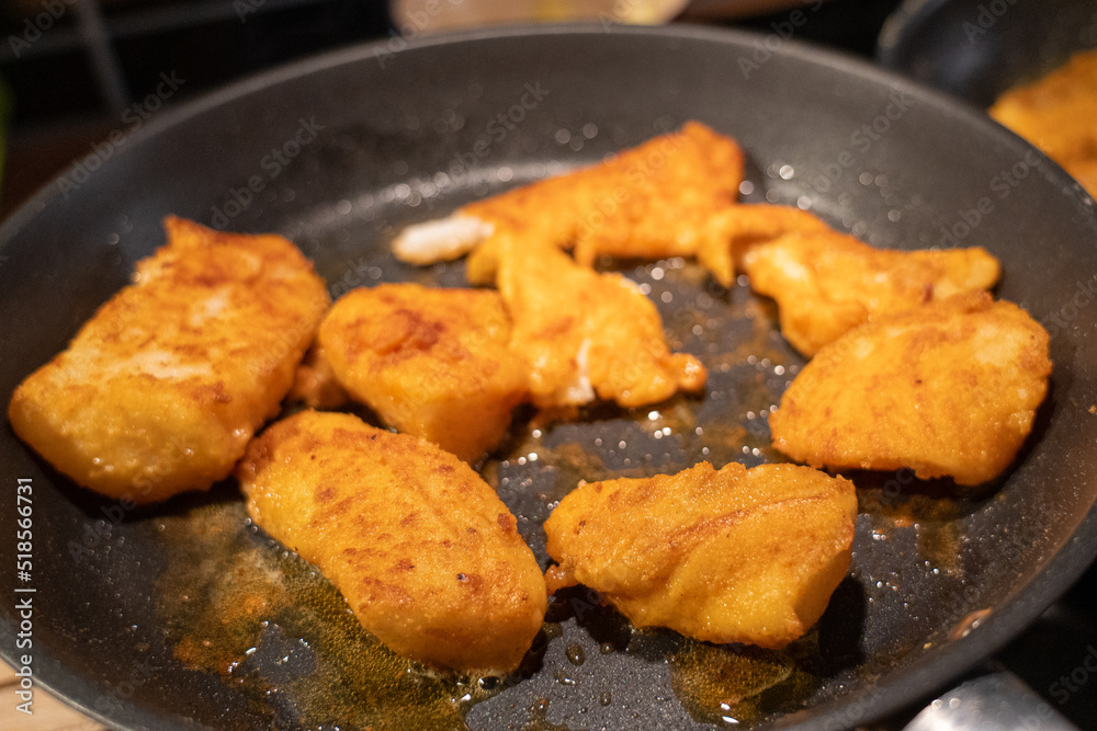 Fish filets being fried in a pan , golden brown colors Fish filets being fried in a pan , golden brown colors