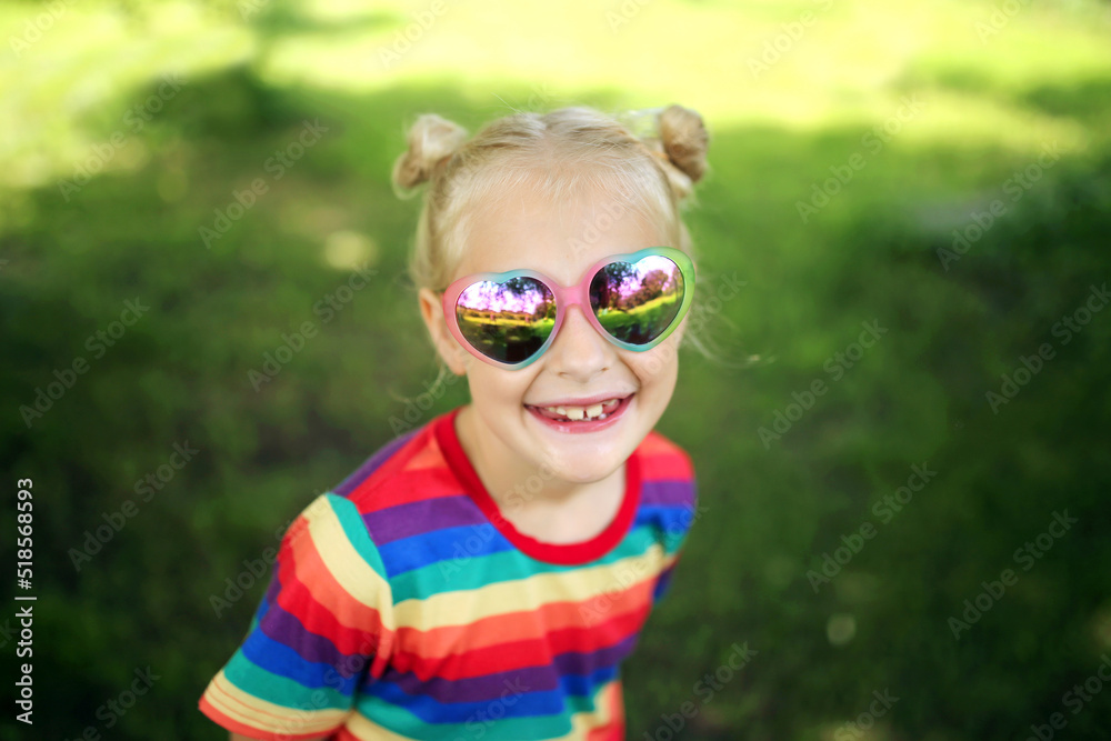 Happy Little Girl Smiling Outside Wearing Heart Shaped Sunglasses Happy Little Girl Smiling Outside Wearing Heart Shaped Sunglasses