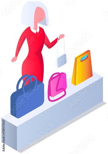Female buyer chooses handbag at exhibition. Lady customer trying on new clutch bag in shopping mall. Choosing clothes and accessories in store concept. Stylish woman in store or fashion boutique