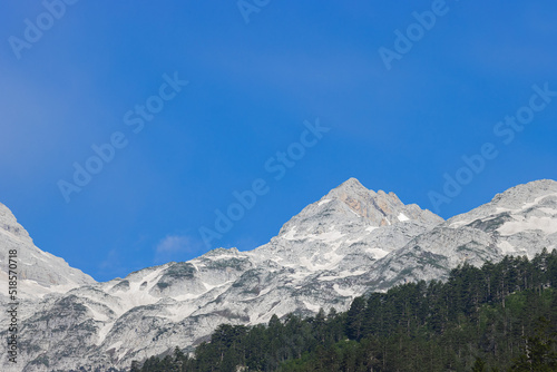 Fototapeta Naklejka Na Ścianę i Meble -  stunning high grey mountain with snow fields on a sunny day and blue sky, alpine area