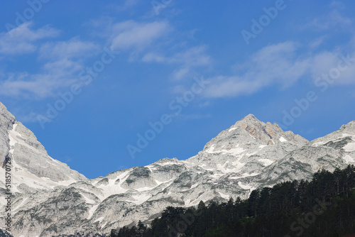 stunning high grey mountain with snow fields on a sunny day and blue sky, alpine area © Africa2008