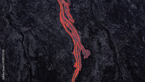 hot lava running on solidified black lava	
 photo