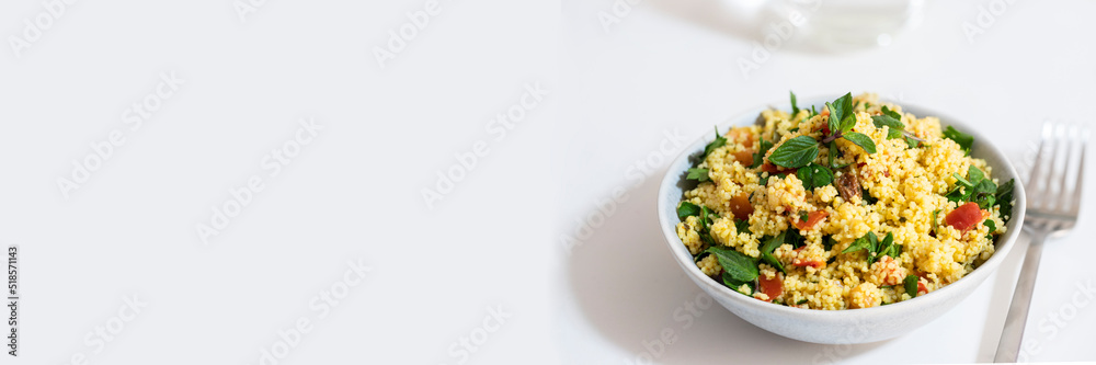 Healthy salad with bulgur, chopped parsley, tomatoes, mint, onion and seasoned with olive oil and lemon juice on white background. Banner Healthy salad with bulgur, chopped parsley, tomatoes, mint, onion and seasoned with olive oil and lemon juice on white background. Banner